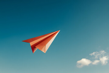 Paper airplane flying against a clear blue sky, symbolizing creativity, imagination, and freedom of thought