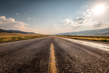 Fototapeta premium An empty open road stretching into the horizon under a bright sky, representing freedom of travel