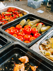 Fresh vegetables and grilled meat displayed at a vibrant outdoor market during summer