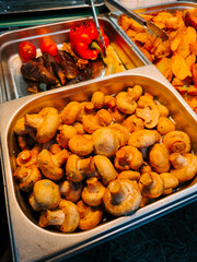Freshly prepared mushrooms served alongside vibrant vegetables at a local market