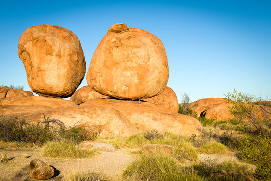 Two large granite boulders balanced on bedrock at Devils Marbles