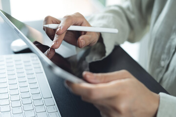 Closeup, business woman using digital tablet, hand holding stylus pen, reading and proofing e-document before signing. Businesswoman working on digital tablet pc, project planning