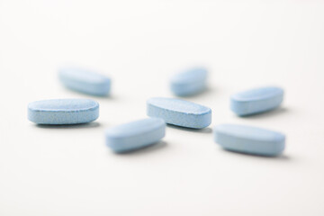 Multivitamin tablets on bright paper background. Close up. Copy space	