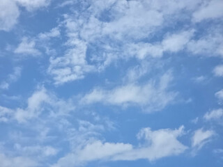 Blue sky with scattered fluffy white clouds in bright daylight. natural outdoor background