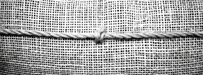 Close-up of a woven fabric with a rope tied across