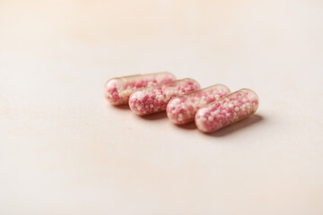 Vitamin B12 (also known as cobalamin) capsules on bright paper background. Soft focus. Close up. Copy space.	