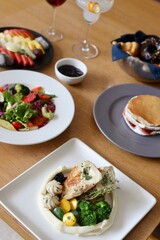 Different kind of food served in a fancy restaurant including fruits, salad and grilled chicken