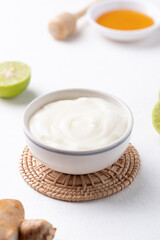 Yogurt, lime, honey and ginger on white background