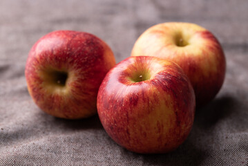 Red apple fruit (Envy apple) on brown fabric background