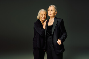 Mature lesbian couple embracing love in elegant attire against a soft backdrop