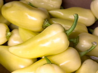 Fresh yellow banana peppers harvested in autumn, piled together for sale, promoting healthy eating, nutrition, and natural benefits for people.