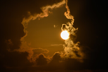 The sun behind a window of thick cumulus clouds