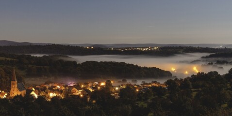 Obraz premium Village Landscape with Misty Hills