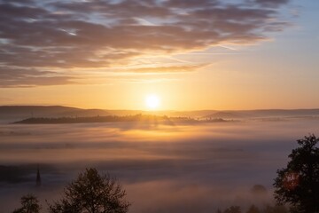 Sunrise over misty landscape with golden glow