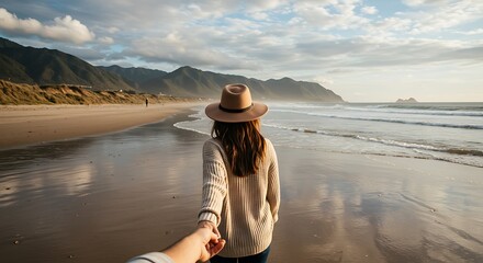 A romantic travel photo from the perspective of a person following their partner on a scenic beach