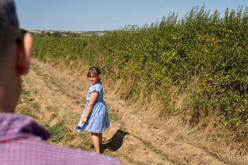 Child girl looking back to her father.