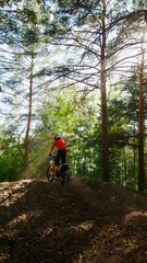 Fototapeta premium A enduro man ride a dirt bike in a forest, from the back