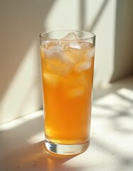 Glass of chilled kombucha with natural effervescence and ice cubes. This fermented tea drink offers a healthy, nonalcoholic, organic option. Bubbles and SCOBY strands are visible, detail shot.