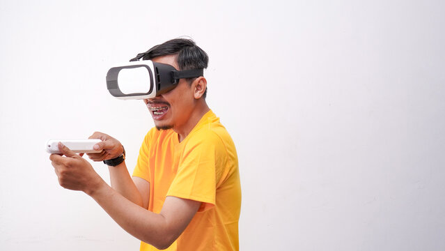 Young man playing with a VR glasses on a white background