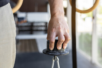 Close-up of a male hand gripping a metal pinch grip during sport-specific exercise for armwrestling training. Perfect for fitness, strength training, home gym and armwrestling technique illustrations