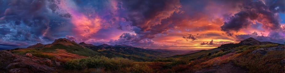 Obraz premium Panoramic view of a mountain range at sunset, with dramatic clouds
