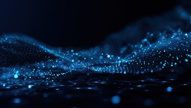 Abstract digital wave of glowing blue particles.  Dark background.  Particles form undulating ridges and soft clouds.  Depth of field effect