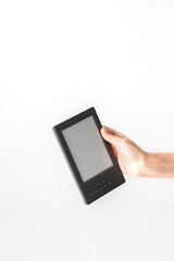 Hand holding vintahe a black e-book reader with a blank screen. The device is slightly tilted, creating a dynamic and natural feel.