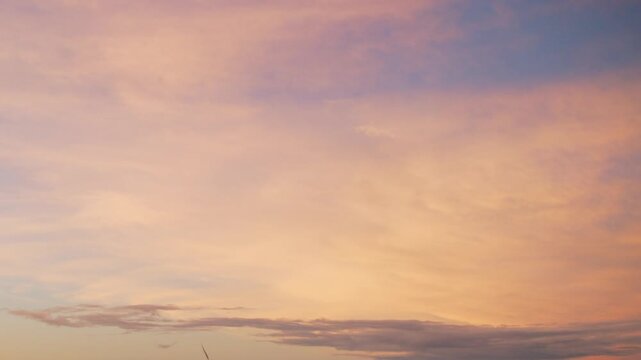 夕日・朝日の茜色に染まった夕焼け朝焼けの空　薄い雲の背景　夏・秋の風景　海と港の海と波の揺らぎ　さみしい色合いの景色