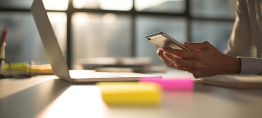 The Smartphone in Hands at Desk with Laptop and Sticky Notes