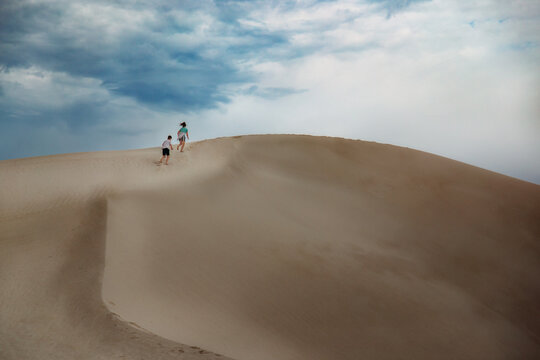 Children Running Up a Sand Dune at White Sands National Park