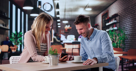 Smiling Analysts Discussing Investments On Smartphone