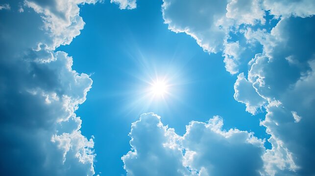 Bright sun shining through a gap in the clouds in a clear blue sky on a beautiful summer day