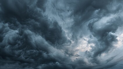A dramatic close-up view of a stormy sky filled with dark, textured clouds