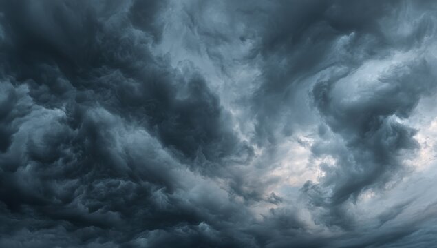 A dramatic close-up view of a stormy sky filled with dark, textured clouds