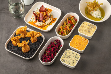 Assorted appetizers with dips, spreads, and vegetables on table