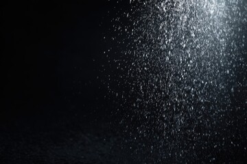 Obraz premium Water droplets cascade against a dark background