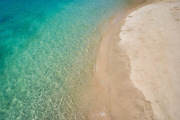 Aerial view of clear ocean water with sand beach for travel.