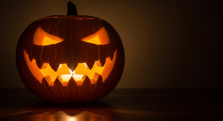 Fototapeta premium Halloween pumpkin carved with a candle glowing inside
