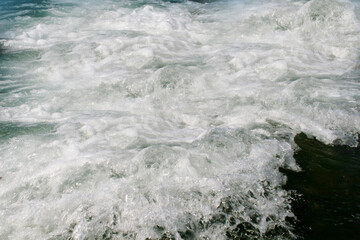 Foaming sea wave on a rocky shore.