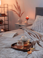 cup of tea on cozy bed with autumn decorations