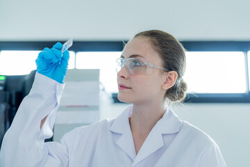 Scientist examines slide in laboratory during research session