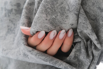 Beautiful women's manicure of milky color with silver stripes. Autumn design