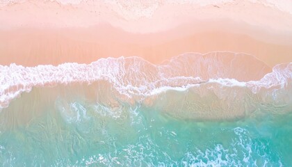 Fototapeta premium An aerial view captures the meeting of a sandy beach and turquoise ocean waves, creating a serene, abstract composition of light and color