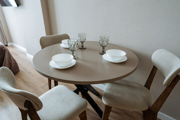 Experience the comfort and warmth of a Cozy Dining Set featuring a Round Table adorned with Elegant Tableware, perfectly suited for a Modern Interior ambiance that enhances your dining experience