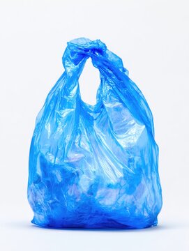 A light blue plastic bag, loosely knotted at the top, stands upright against a white background; it appears to contain crumpled white items