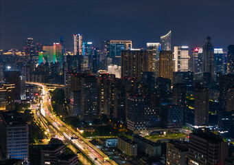 Fototapeta premium Hangzhou cityscape displays illuminated skyscrapers and a busy highway during the evening hours