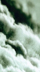Ethereal view of fluffy, swirling cloud formations in muted green tones, creating a dreamy and abstract skyscape
