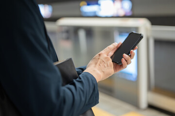Fototapeta na wymiar 駅でスマホを操作する男性の手元