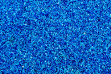 a densely packed, textured surface covered in small, irregularly shaped blue gravel or pebbles.