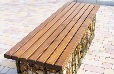 Modern bench design combining wood and metal creates a unique outdoor seating area in a public space